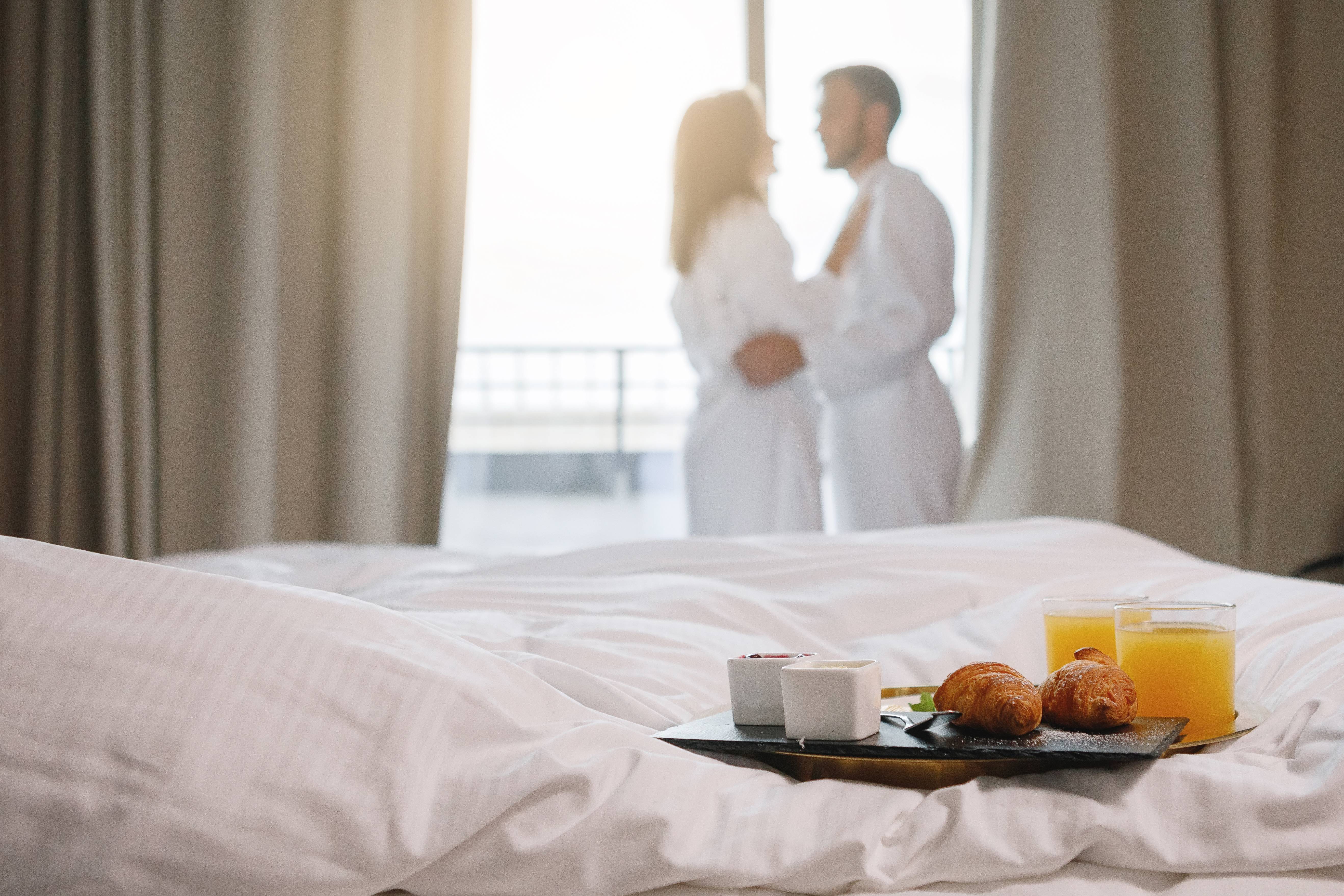 Breakfast in bed with romantic couple in background