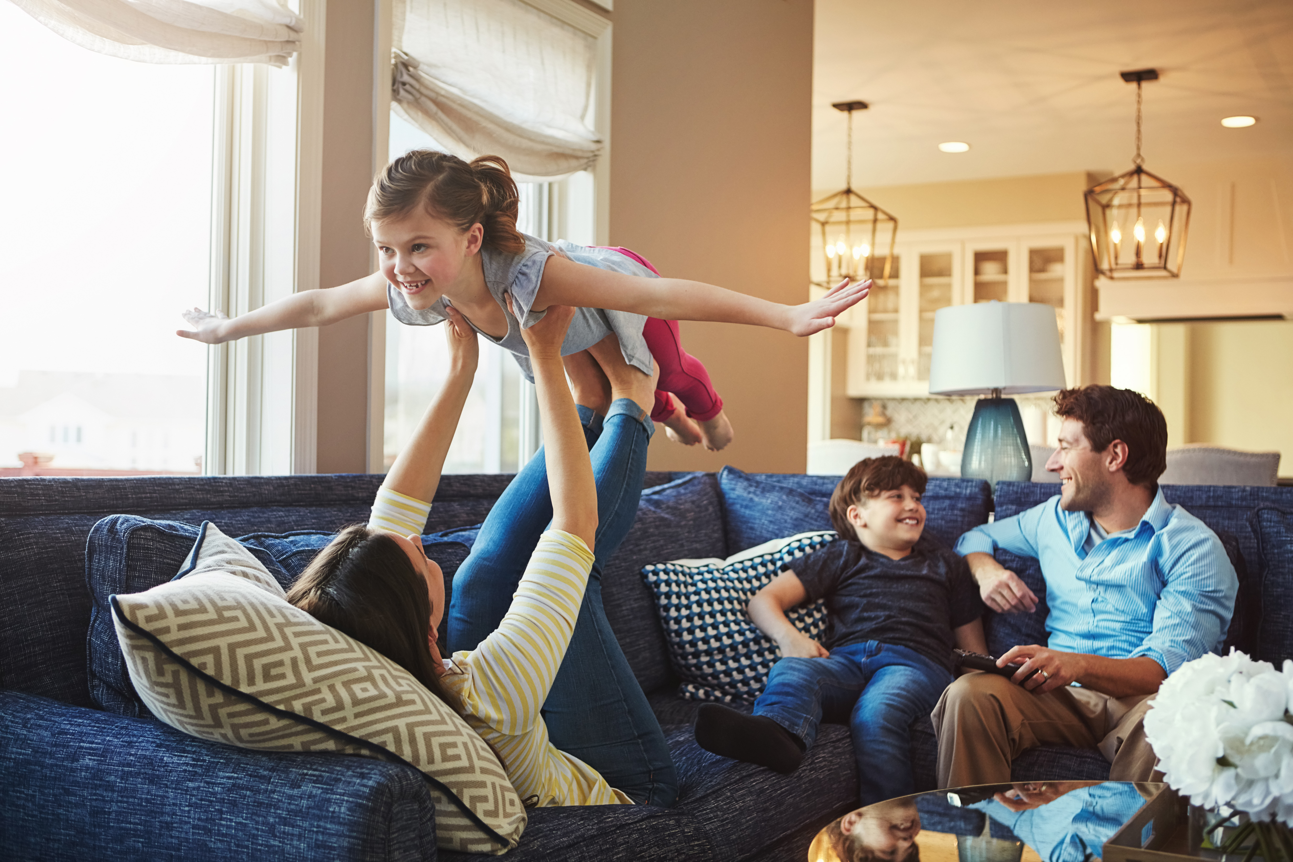 Family in a lounge with girl flying